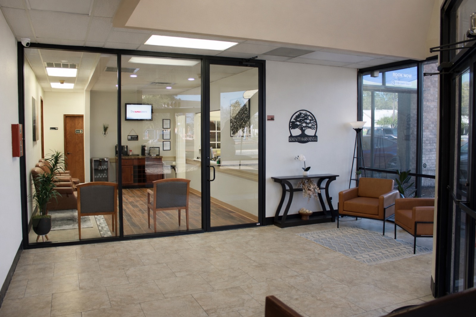 The building lobby, with the Serenity Oaks Dental oak tree logo on the wall and glass doors into the office