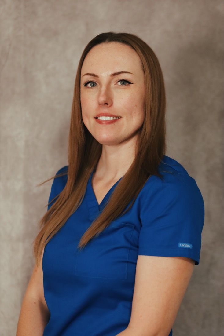 Carmen, smiling, in blue scrubs